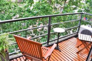 a balcony with two chairs and a table and a fan at Corrientes y Riobamba in Buenos Aires