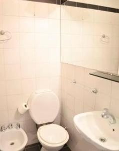 a white bathroom with a toilet and a sink at Corrientes y Riobamba in Buenos Aires