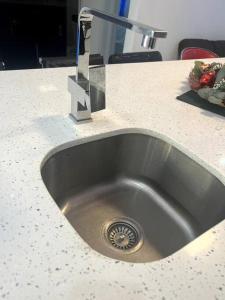a kitchen sink with a faucet on a counter at Cozy One-Bedroom Retreat in Maverty