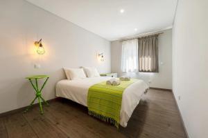 um quarto com uma cama grande e um cobertor verde em Beach Retreat em Torres Vedras