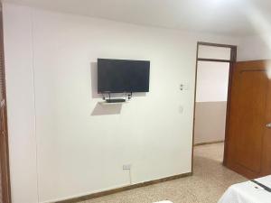 einen Flachbild-TV an einer weißen Wand in der Unterkunft Sweet Home RIOHACHA in Ríohacha