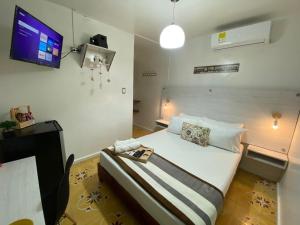 a bedroom with a bed with a tv on the wall at Hotel Nogales Riohacha in Ríohacha