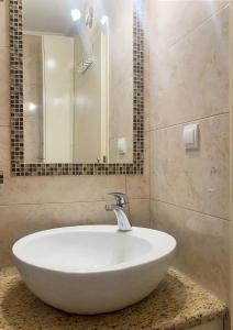 een badkamer met een witte wastafel en een spiegel bij BAJKA in Čačak