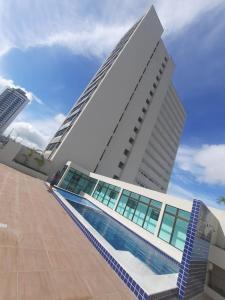 a building with a swimming pool in front of it at Vizinho ao Shopping Caruaru Cobertura 14 andar in Caruaru