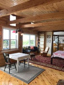a living room with a table and chairs and a bed at MareGold Centre - Juniper Cabin and Rose Cabin in Victoria Beach 