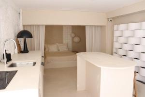 een witte keuken met een wastafel en een bed bij CASA SCANDIC FAMILY GUEST HOUSE rooms&apartments in Matosinhos