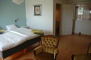 ein Schlafzimmer mit einem Bett und einem Stuhl darin in der Unterkunft Sundsmåla Landsbygdshotell in Brokind