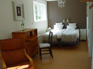 ein Schlafzimmer mit einem Bett mit einem Stuhl und einem Tisch in der Unterkunft Sundsmåla Landsbygdshotell in Brokind