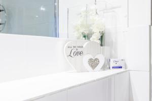 a white shelf with a heart sign on it at Canary Wharf Apartments By Austin David in London