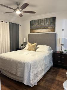 a bedroom with a white bed with a ceiling fan at Tampa Citrus Park in Tampa