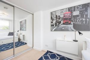 a bedroom with a double decker bus picture on the wall at Canary Wharf Apartments By Austin David in London