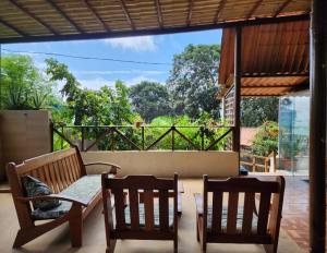 eine Terrasse mit 2 Holzstühlen und einem Tisch in der Unterkunft Casa do Maneco in Fernando de Noronha