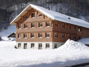 a building covered in snow with a pile of snow at Haus Schwendinger in Mellau