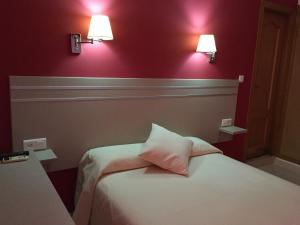 sypialnia z 2 łóżkami i 2 lampkami na ścianie w obiekcie Hotel Carmen Teresa w mieście Torremolinos +23 zdjęcia