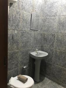 a bathroom with a sink and a toilet at Hospedagem Econômica By Bia in Penha