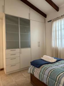 聖胡安的住宿－Villa Licciana，一间卧室配有床和白色的大橱柜