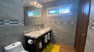 uma casa de banho com um lavatório, um WC e um espelho. em CASA DEL LAGO em Cachí
