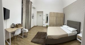 - une chambre avec un lit, un bureau et une télévision dans l'établissement B&b Vesuviano, à Ercolano