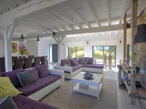 een woonkamer met paarse banken en een tafel bij Inviting holiday home in Gourdon with terrace in Gourdon-en-quercy