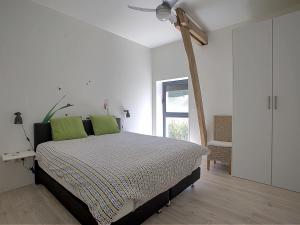 een slaapkamer met een bed met groene kussens en een plafondventilator bij Inviting holiday home in Gourdon with terrace in Gourdon-en-quercy