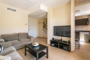 ein Wohnzimmer mit einem Sofa und einem Flachbild-TV in der Unterkunft Ferienhaus für 4 Personen ca 105 m in Sa Rapita, Mallorca Südküste von Mallorca - a88430 in Sa Ràpita