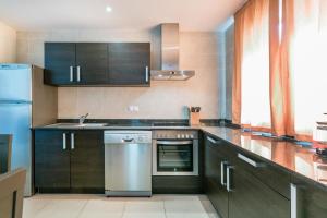 eine Küche mit schwarzen Schränken und einem Kühlschrank aus Edelstahl in der Unterkunft Ferienhaus für 4 Personen ca 105 m in Sa Rapita, Mallorca Südküste von Mallorca - a88430 in Sa Ràpita