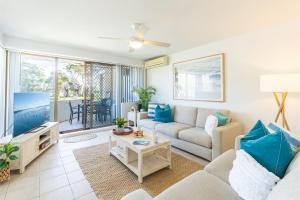 a living room with a couch and a tv at Fleetwood 4 Air conditioned unit with water views in Shoal Bay