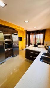 a kitchen with stainless steel appliances and a living room at Hermosa Villa L'Ardiaca in Cambrils
