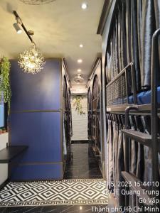 a hallway with a blue wall with racks of clothes at HOMSTAY 1106 QUANG TRUNG in Ho Chi Minh City