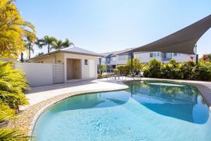 a swimming pool in front of a house at Noosa Haven Apt 6 Riverside Retreat in Noosaville