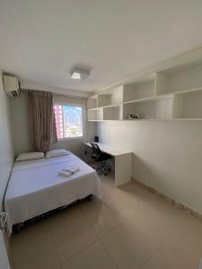 1 dormitorio con cama, escritorio y ventana en TEMPORADA737 Top 3 Quartos na Atalaia Condominio Clube com Piscina, en Aracaju