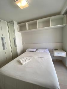 Un pequeño dormitorio con una cama blanca y estanterías en TEMPORADA737 Top 3 Quartos na Atalaia Condominio Clube com Piscina, en Aracaju