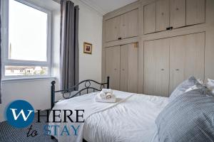 een slaapkamer met een bed met een raam en een bordje waarop staat waar je moet verblijven bij Charming 2 bedroom apartment in Gorgie in Edinburgh +10 foto's