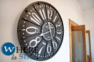a black and white clock on a wall at Charming 2 bedroom apartment in Gorgie in Edinburgh