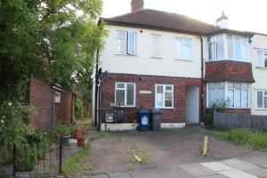 a white and red brick house with a driveway at Cozy light single bedroom in Edgware
