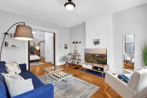 a living room with a blue couch and a tv at Modern European 1BR near DT-Historic St in Columbus
