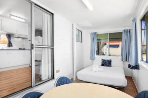 a small room with a bed and a table and chairs at Pyramid Holiday Park in Tweed Heads