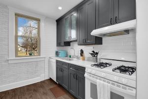 a kitchen with black cabinets and a stove top oven at Modern European 1BR near DT-Historic St in Columbus