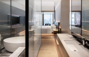 uma casa de banho com uma banheira, um WC e um lavatório. em Renaissance Shenzhen Bay Hotel em Shenzhen
