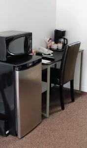 una mesa con TV y una silla junto a un escritorio en White Fang Motel, en Wawa