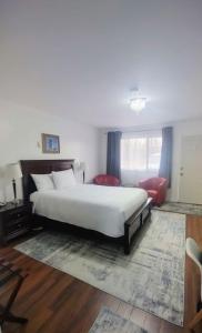 a bedroom with a white bed and a red chair at White Fang Motel in Wawa