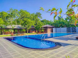 a swimming pool in front of a house at Doola River Edge in Udawalawe