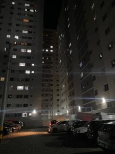 a parking lot with cars parked in front of tall buildings at Millennium Residence in Juiz de Fora