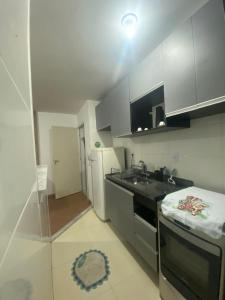 a small kitchen with a sink and a stove at Millennium Residence in Juiz de Fora