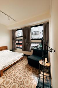 une chambre d'hôtel avec un lit et une chaise dans l'établissement 鴉埠客棧x南華大旅社, 