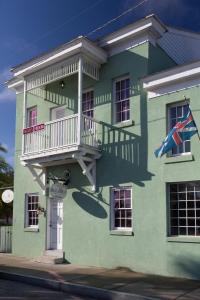 a green house with a balcony on the side of it at Bella Bay Inn in St. Augustine