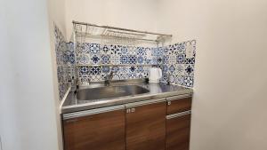 eine Küche mit einem Waschbecken und blauen und weißen Fliesen in der Unterkunft ZUMI TERRACE うちなーみやリゾート宮古島 in Miyako-jima