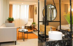 baño con lavabo y sala de estar. en Guangzhou Homies Hotel, en Guangzhou