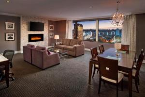 a living room with a table and a dining room at Sheraton Hamilton Hotel in Hamilton