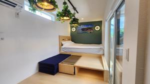 ein kleines Zimmer mit einem Bett und einem Fenster in der Unterkunft ZUMI TERRACE うちなーみやリゾート宮古島 in Miyako-jima